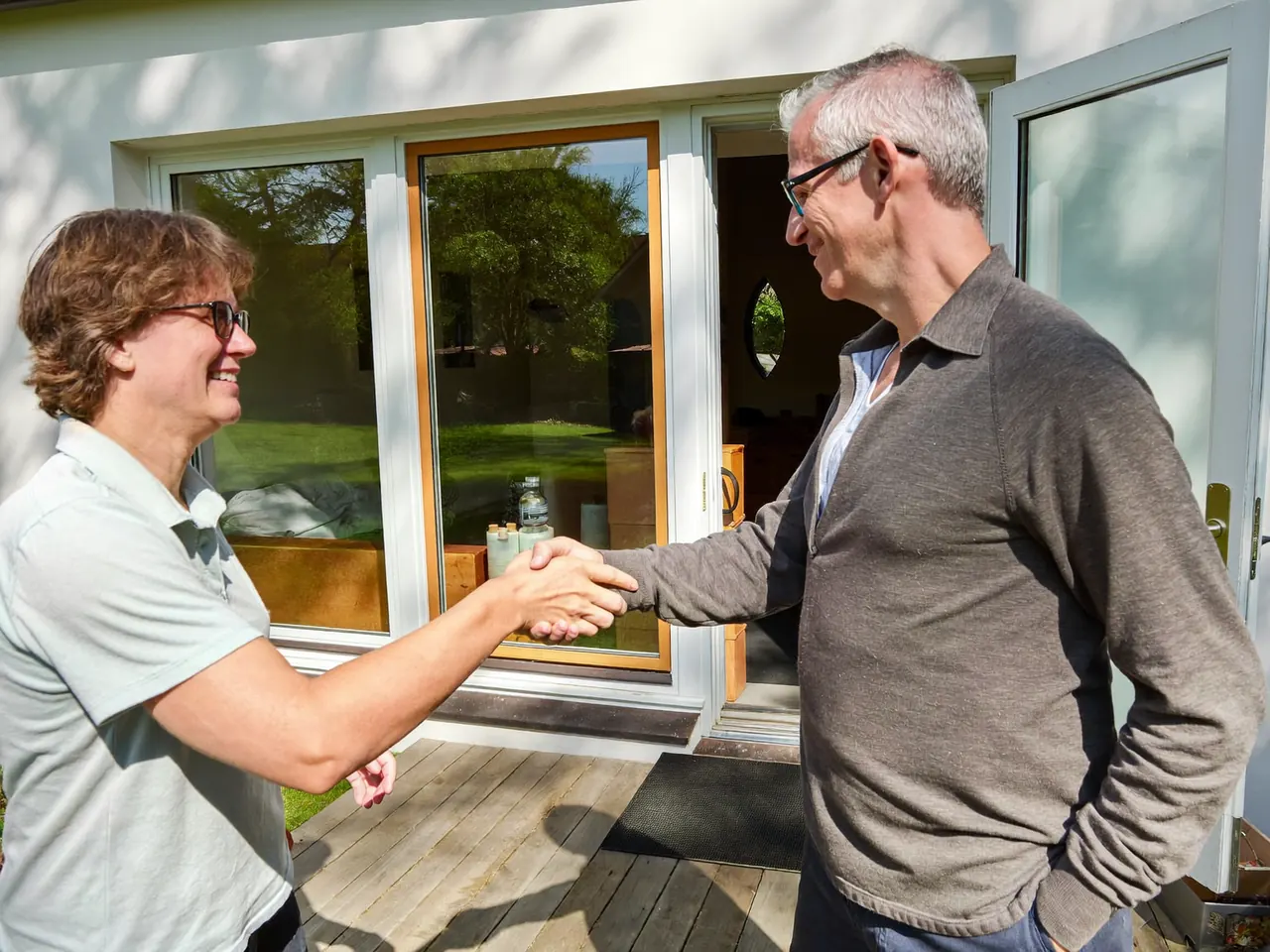 Installer shaking hands with a homeowner on a doorstep